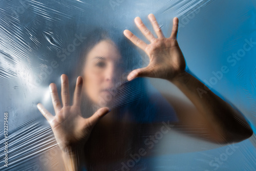 Woman touching plastic film while standing behind it photo