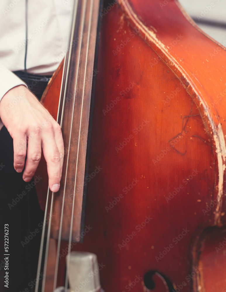 Contrabass cellist player in headphones during rehearsal, recording sound for new album song at studio, cello violoncellist musician with microphone and musical band orchestra, music production Contrabass cellist player in headphones during rehearsal, recording sound for new album song at studio, cello violoncellist musician with microphone and musical band orchestra, music production