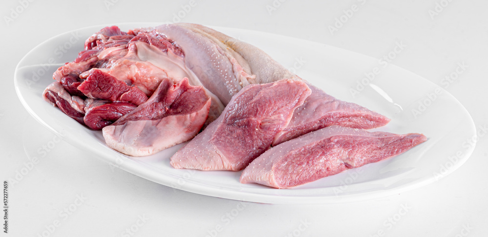 Fresh pork offal on a white plate on a white background Fresh pork offal on a white plate on a white background