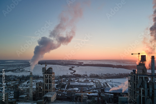 Aerial view of cement factory tower with high concrete plant structure at industrial production area at sunset. Manufacturing and global industry concept