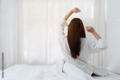 Beautiful asian woman has woken up on a white bed in the morning at home. lifestyle concept