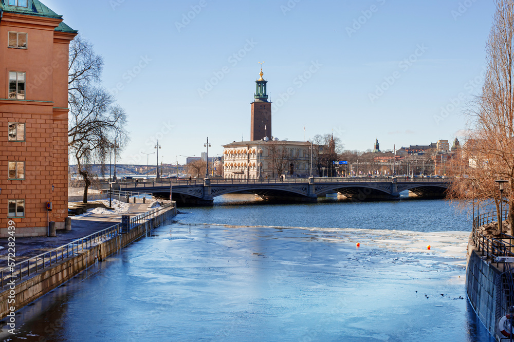 view of stockholm city hall stadhuset from the frozen river with melting ice