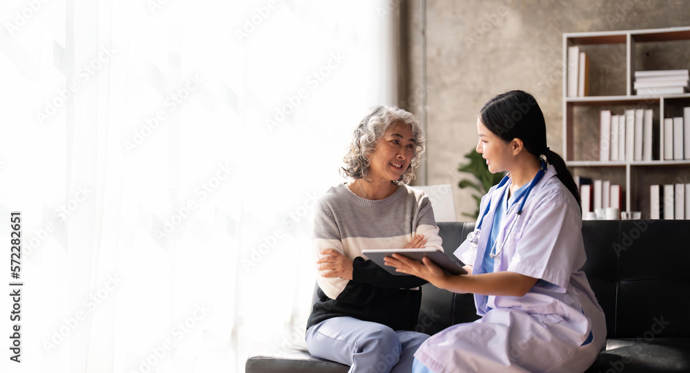 Nurse talking with a nursing home patient about his health. The nurse is making notes on a digital tablet Nurse talking with a nursing home patient about his health. The nurse is making notes on a digital tablet