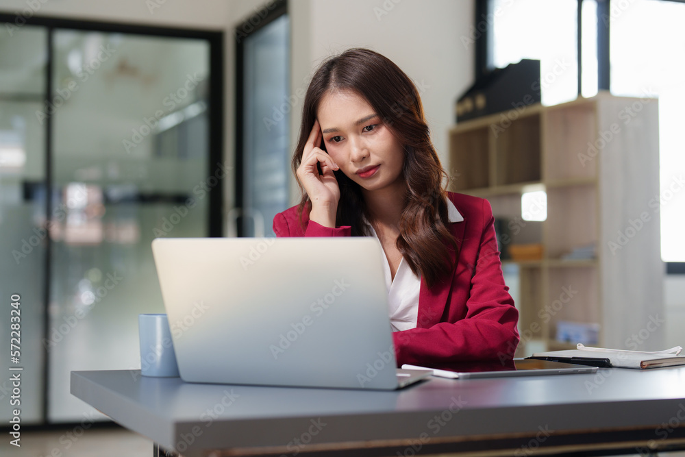 Stressed Business woman checking budget of company, taxes, bank account balance and calculating expenses at office Stressed Business woman checking budget of company, taxes, bank account balance and calculating expenses at office