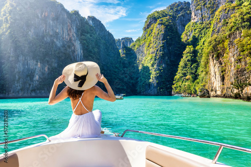 Elegant traveler woman in summer dress relaxing on boat at Maya beach, Phi Phi island, Tourism Phuket, Krabi, Travel concept for Thailand