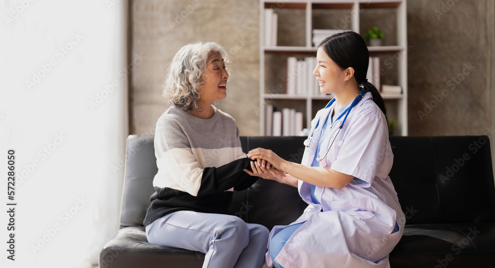 Obraz premium Home caregiver and senior woman holding hands. Professional Elderly Care. Professional care for elderly at nursing homes. Nurse holding hand of senior woman in rest home
