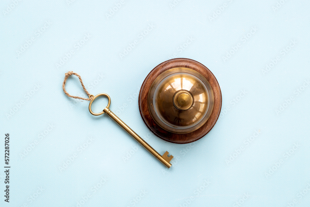 Golden hotel service bell with key on reception desk Golden hotel service bell with key on reception desk