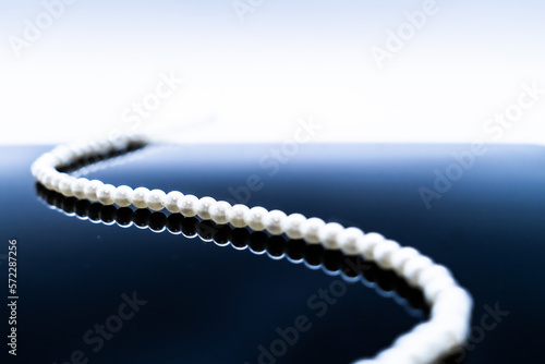 pearl necklace on blue background © Yan