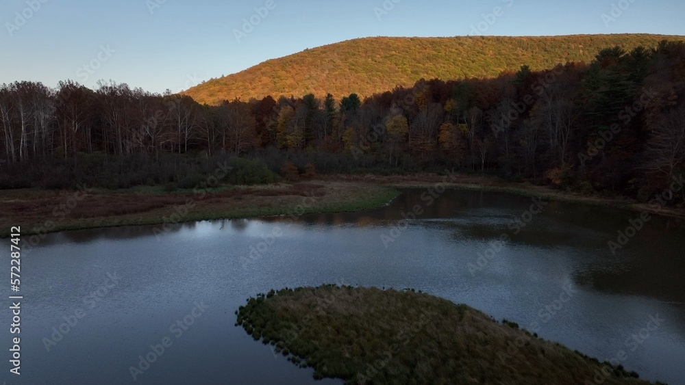 Protected wetland marsh conservation area beside mountain with trees during Autumn with Fall colors Protected wetland marsh conservation area beside mountain with trees during Autumn with Fall colors