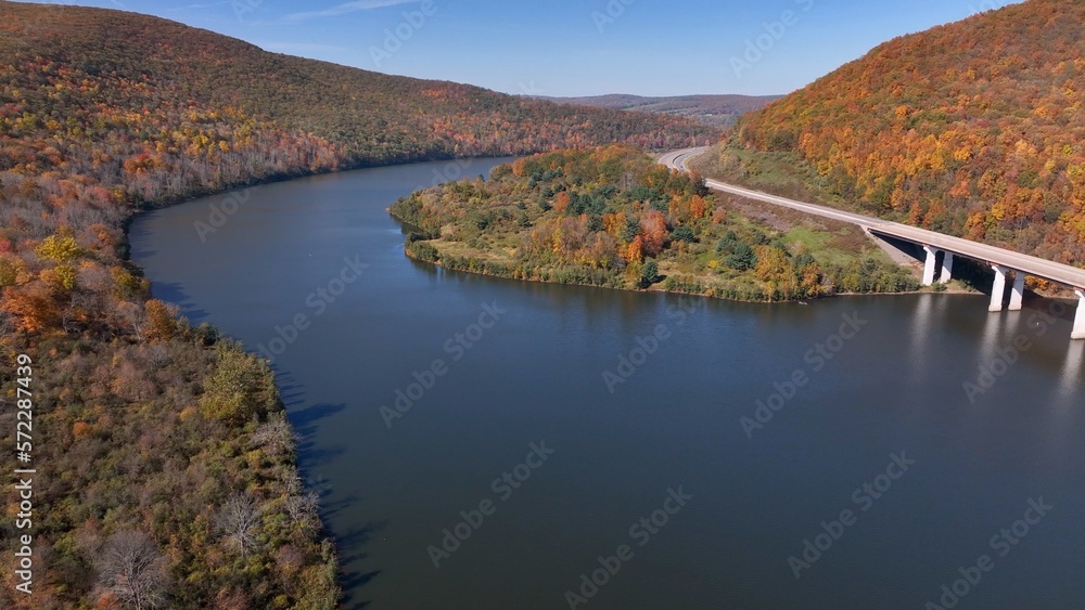 Traveling on highway through mountains in Pennsylvania beside Tioga reservoir during Autumn with Fall colors