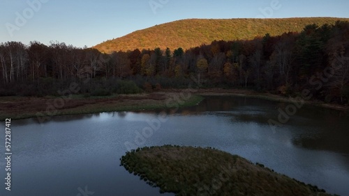 Protected wetland marsh conservation area beside mountain with trees during Autumn with Fall colors