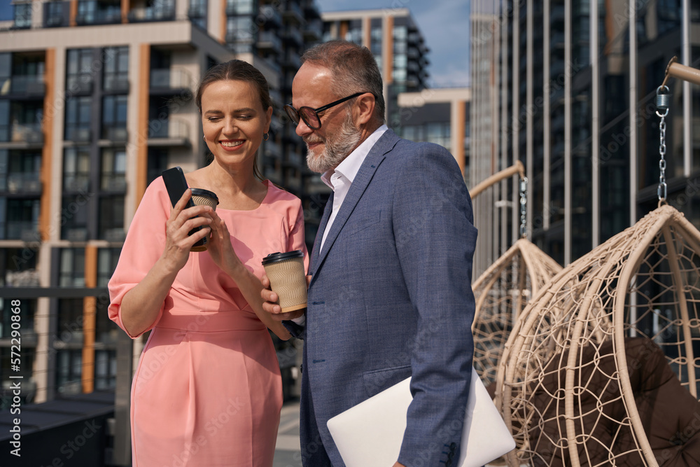Businesswoman communicates with business partner on terrace of business center Businesswoman communicates with business partner on terrace of business center