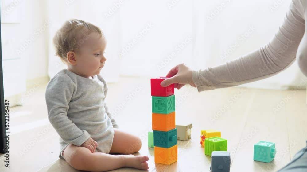 Child playing with colorful toy blocks with mother. Kids play. Educational game for baby and toddler Child playing with colorful toy blocks with mother. Kids play. Educational game for baby and toddler