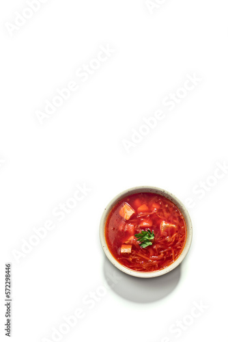 Ukrainian borscht in a plate on a white background, top view