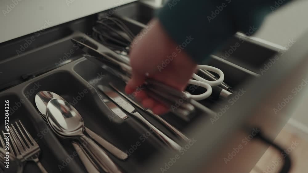 Frau räumt Messer aus der Spülmaschine in die Besteck Schublade. Frau räumt Messer aus der Spülmaschine in die Besteck Schublade.