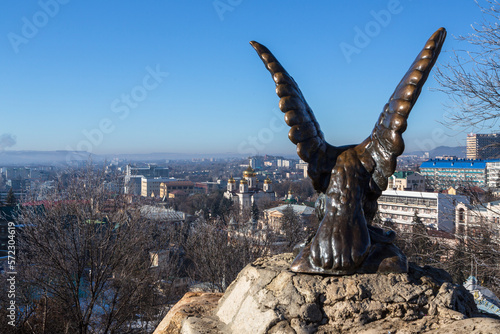 Pyatigorsk  Russia - December 2020  Ancient sculpture  Eagle tormenting a snake  against the background of the city of Pyatigorsk