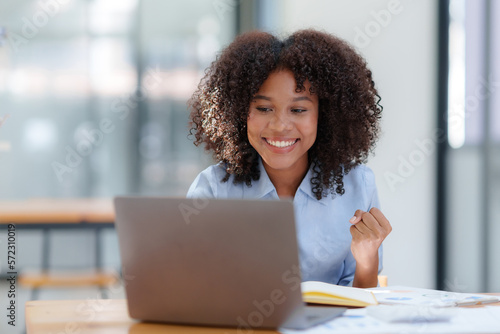 Businesswoman raising her hand in congratulation with document and laptop computer