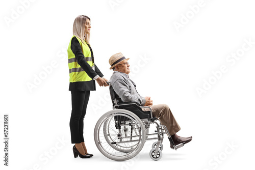 Female special assitance worker standing with a senior man in a wheelchair