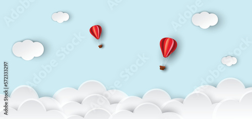 Hot air balloons and clouds on abstract blue sky background. Hot air balloons rise in the sky. paper cut and craft design. vector illustration.