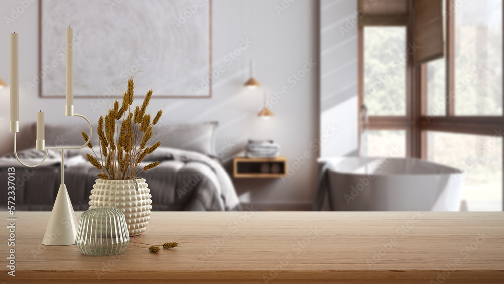 Wooden table, desk or shelf close up with ceramic and glass vases with dry plants, straws over blurred view of japandi bedroom with bathtub, modern interior design concept