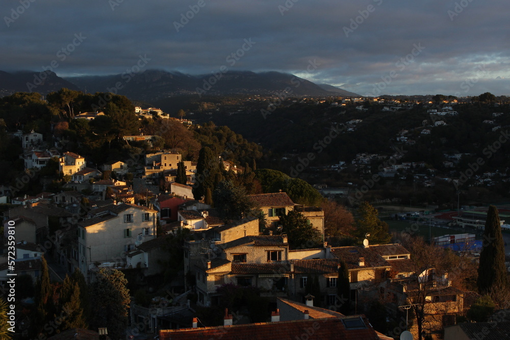 Sun breaking on the ancient medieval town of Cagnes sur Mer in the French Riviera - Mediterranean Travel concept wallpaper or background. Sunrise over tiny ancient medieval village in South of France