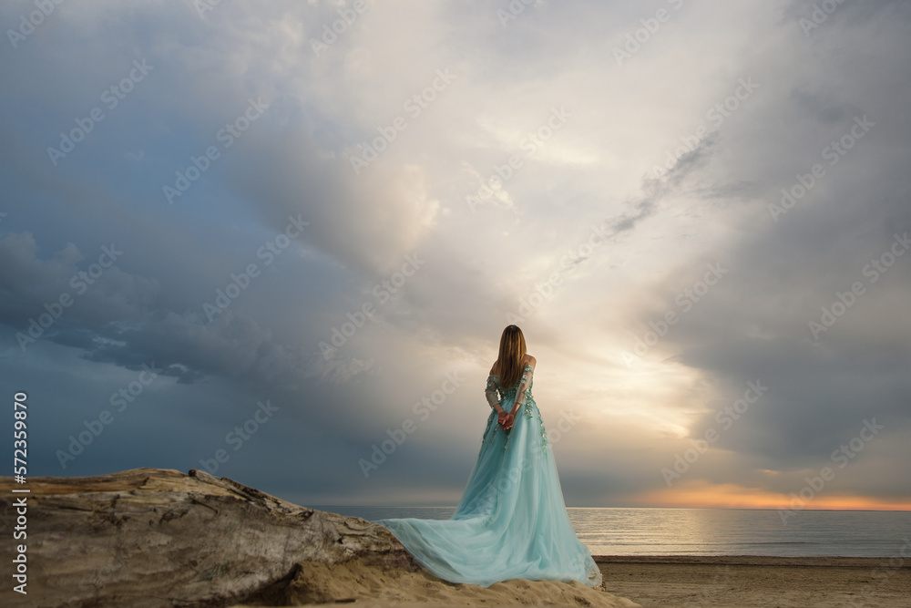 girl in a blue dress looking at the sea girl in a blue dress looking at the sea