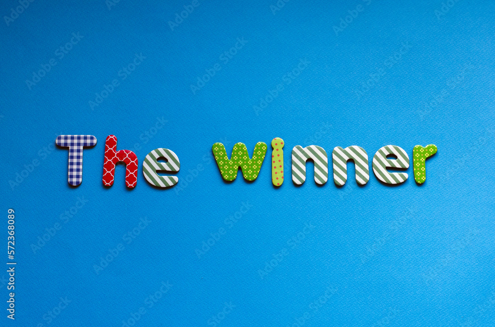 colored word  the winner on blue paper background