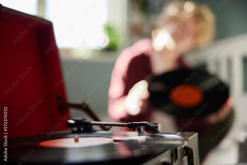 Teenage Girl Playing Vinyl Records On Record Player At Home In Bedroom With Focus On Foreground Teenage Girl Playing Vinyl Records On Record Player At Home In Bedroom With Focus On Foreground