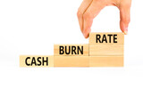 Cash burn rate symbol. Concept words Cash burn rate on wooden blocks on a beautiful white table white background. Businessman hand. Business cash burn rate concept. Copy space.