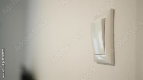 Opening the Light from the Switch in the Office. One Person Turning on the Light in a Room. Saving Electricity, Economy Concept.