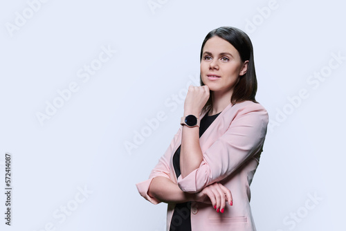 Pensive young woman looking away on white background