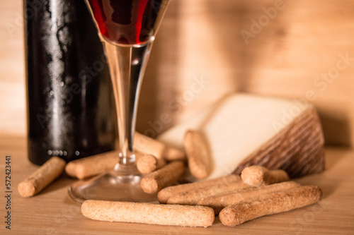 una botella de vino tinto con una copa y maridaje de queso photo