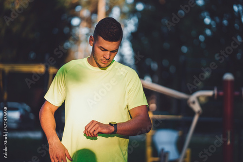 Waist au fit man looking down at his watch after a run © VisualProduction