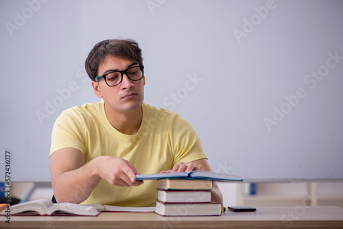 Young male student sitting in the classroom