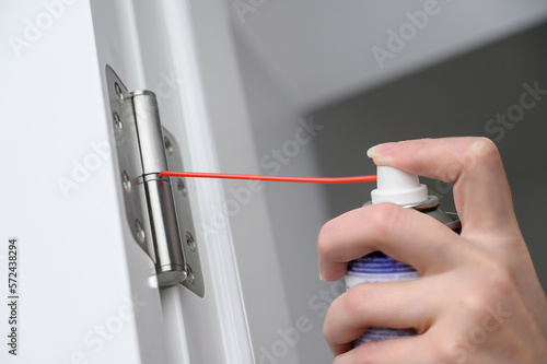 Fotografie A man greases door hinges