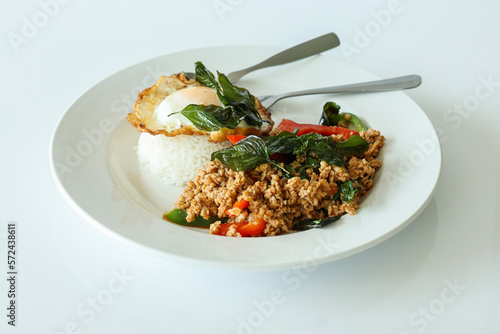 Pad Kra Pow with chicken in bowl with rice and fried thai basil