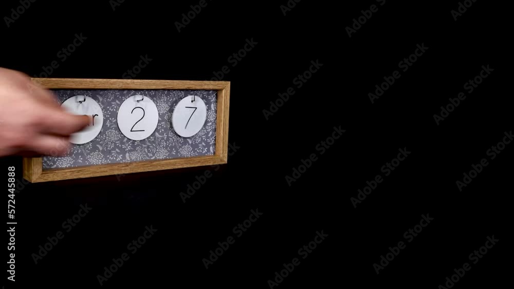 A wooden calendar block showing the date March 27th which is Mothering Sunday mothers day with a mans hand putting on and taking off the metal discs with the date month on them, filmed in 4k quality A wooden calendar block showing the date March 27th which is Mothering Sunday mothers day with a mans hand putting on and taking off the metal discs with the date month on them, filmed in 4k quality