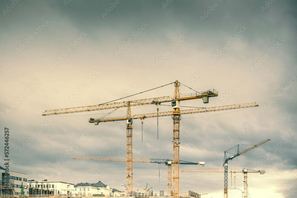 Construction site with yellow cranes on a cloudy day. Development area Construction site with yellow cranes on a cloudy day. Development area
