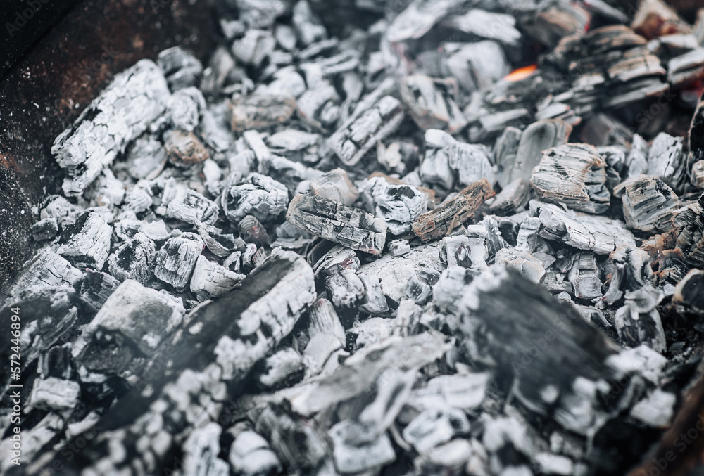 Close-up photo of smoldering gray coals, burnt ash close-up in a bonfire, fire. Close-up photo of smoldering gray coals, burnt ash close-up in a bonfire, fire.