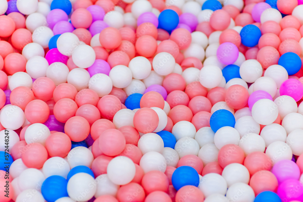 Background, close-up texture of many colored, multi-colored round plastic small balls on the playground for children's games. Photography, top view, copy space, childhood concept. Background, close-up texture of many colored, multi-colored round plastic small balls on the playground for children's games. Photography, top view, copy space, childhood concept.