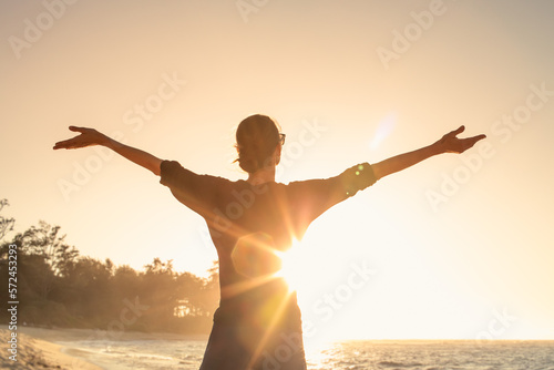 Photo Young female feeling grateful, joyful standing outdoors in the sunrise