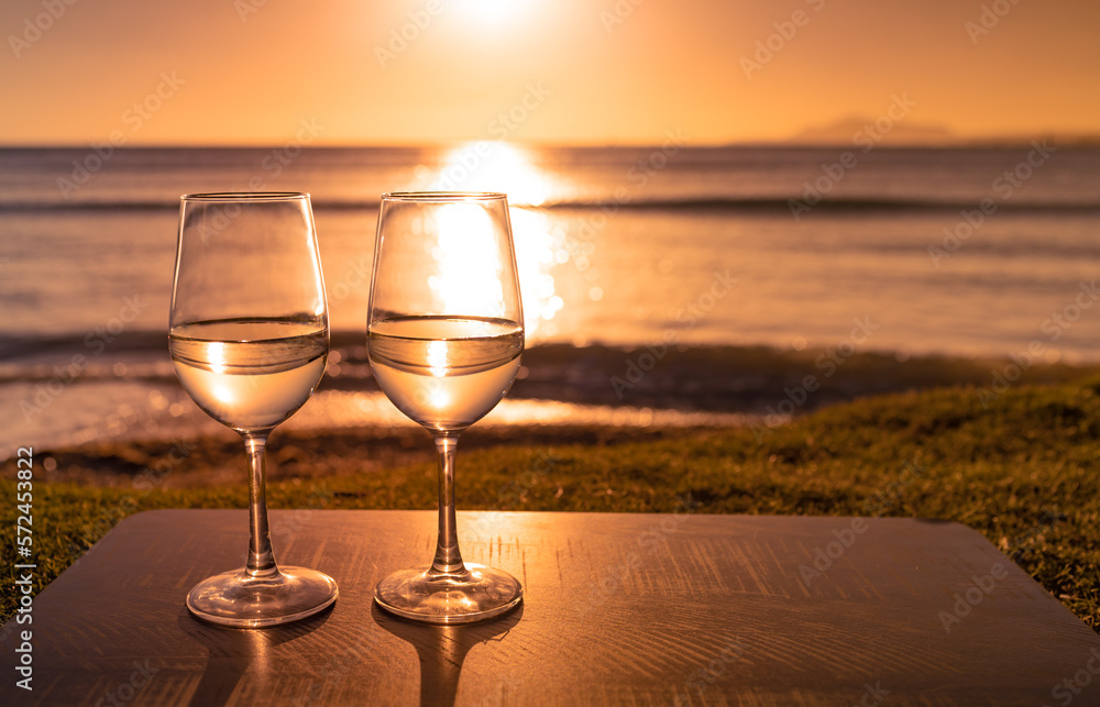 glasses of wine at ocean sunset view - obrazy, fototapety, plakaty 