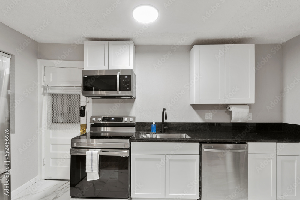 White apartment with wide open spaces, hardwood flooring and modern furniture. Used as a short term rental. White apartment with wide open spaces, hardwood flooring and modern furniture. Used as a short term rental.