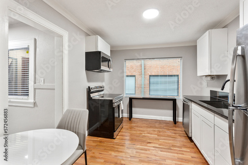 White apartment with wide open spaces  hardwood flooring and modern furniture. Used as a short term rental. 