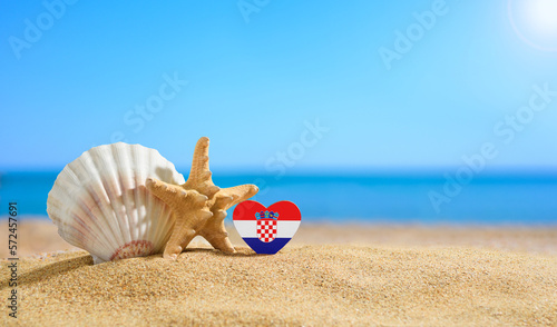 Beautiful beach in Croatia. Flag of Croatia in the shape of a heart and shells on a sandy beach.