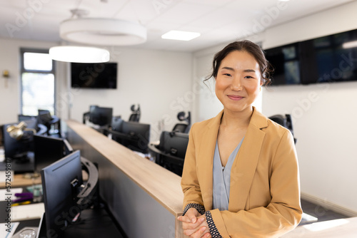 Happy asian businesswoman looking at camera in office