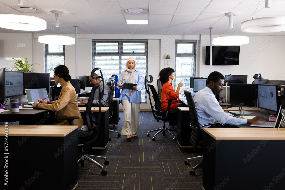 Diverse female and male businesspeople working in office with open space Diverse female and male businesspeople working in office with open space