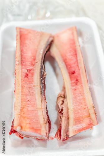 Foto Raw uncooked beef marrow bones for roasting macro closeup with texture of pink r