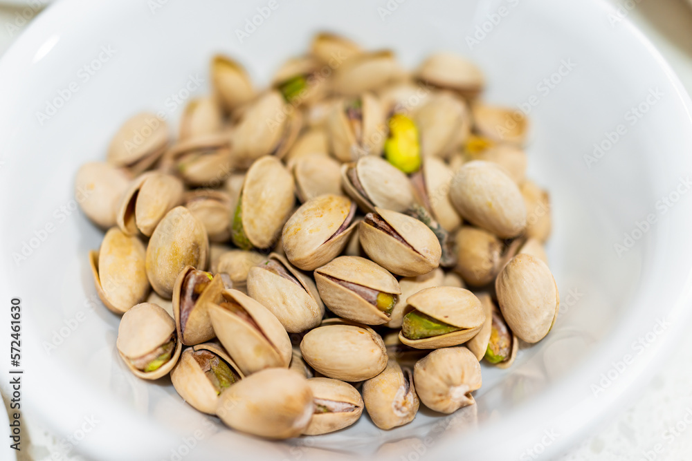 Pistachios green nut unshelled brown color shells with pile of group of many with texture macro closeup Pistachios green nut unshelled brown color shells with pile of group of many with texture macro closeup