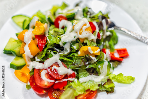 Obraz na plátne Fresh creamy dressing on chopped vegetable vegan salad closeup with bell peppers